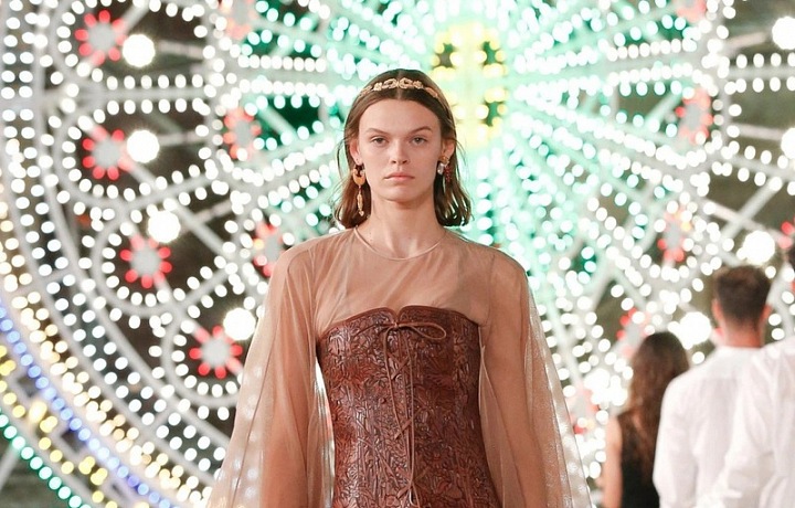 Žena v nude šatech Dior