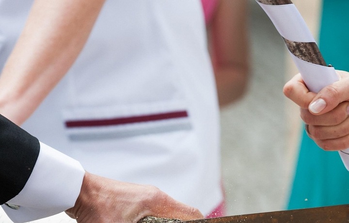 „Baumstamm sägen“ je tradice, při které novomanželé společně pilují dřevěný klád.