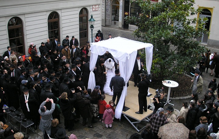 The wedding ceremony takes place under the chuppah