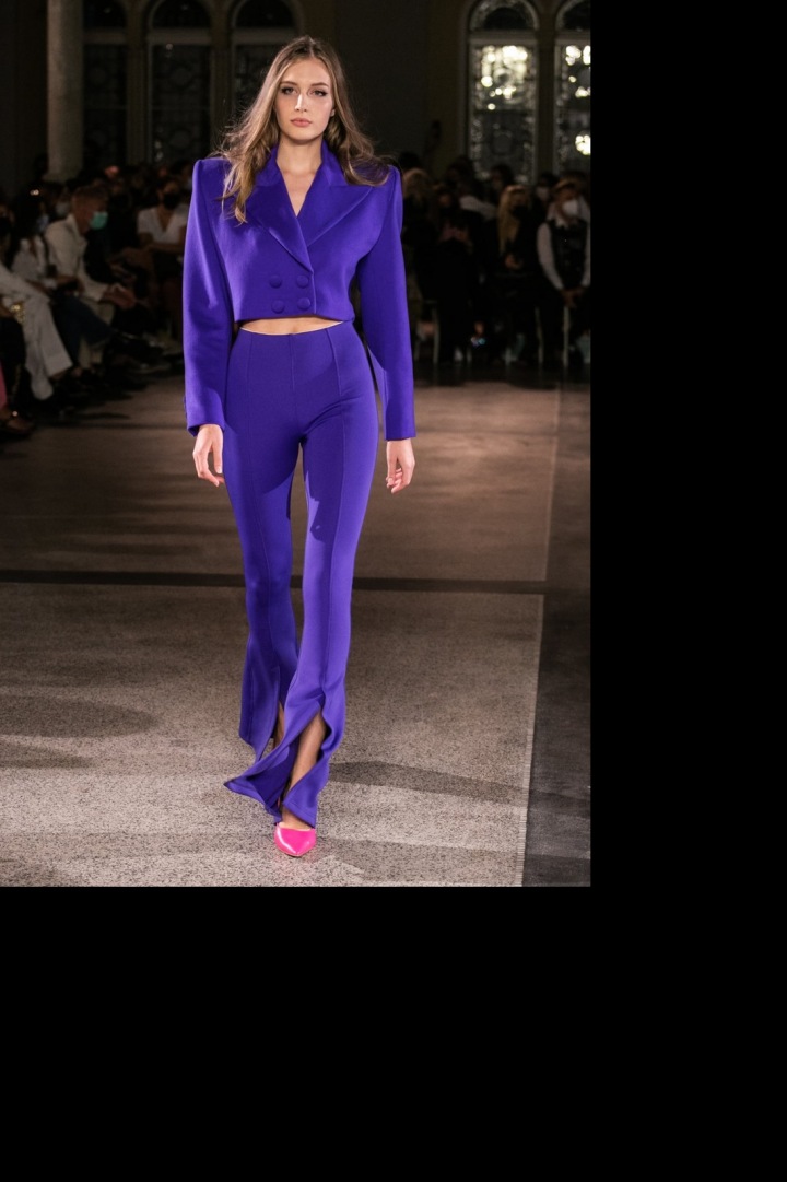 Modelka má na sobě fialový kostýmek od Vandy Jandy