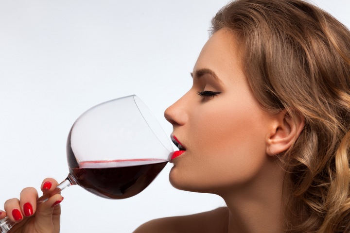 Žena pije víno.