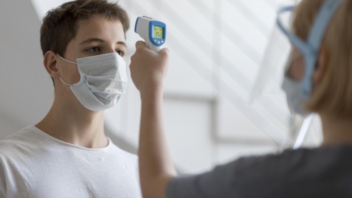 Lékař měří muži teplotu