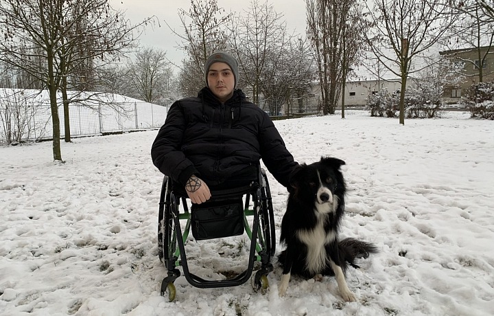 Daniel Křeček na vozíku se svým psem. 