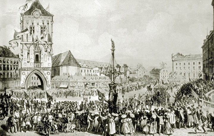 Ilustrace zachycuje slavnostní průvod Prahou u příležitosti položení základního kamene (16.5.1868).