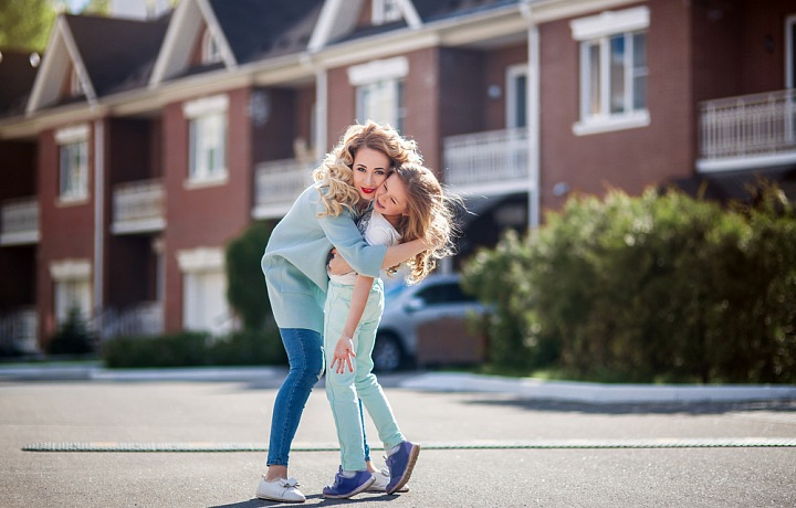 Matka s dcerou na ulici před řadovými domky